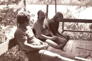 Photo of 1975. Dick Fernandez, Paul Kittlaus, Adam Kittlaus chatting at Squam Lake, NH.