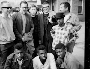 Photo of Selma 1971. Bottom Row: local young men; Clemie Tynes, Lloyd Cleveland, James Alexander, Clifton Barker. Top Row: from Southern California; George Killingworth, Paul Kittlaus, Lynn Jondahl, Al Cohen, Pete Flint. Waiting for the march to assemble.